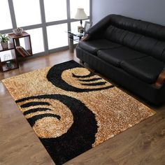 a living room area with a couch and rug on the wooden floor next to a window