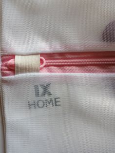 a close up of the zippers on a white shirt with pink trim and an embellishment