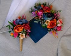 two boutonnieres with colorful flowers on them