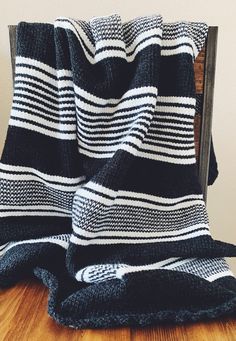 a black and white blanket sitting on top of a wooden table