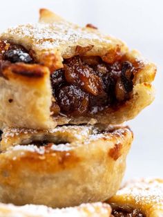 three pastries stacked on top of each other with powdered sugar and raisins