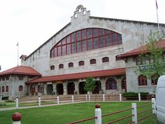 an old building with red roof and white fence