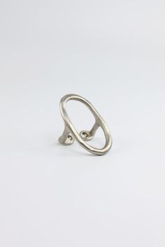 a silver ring on a white surface with the letter o in it's center