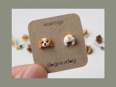 the small dog earrings are made out of wood and have tiny white dogs on them