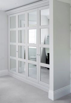 an empty room with white walls and glass doors