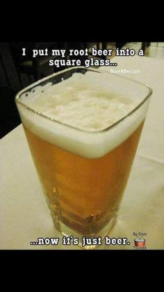 a glass filled with beer sitting on top of a table