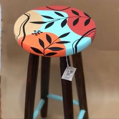 a stool with an orange and blue floral design on it