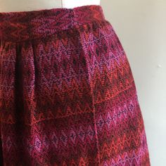 "Kicky little mini skirt in the with the best fabric. Color is a vibrant combination of reds with pink and black. Fits at the waist in wrap style with hook and eye closures. Label is Mr Mort (when it is good it is good!). Condition is Great. Was stored. Measurements (all flat) 13\" waist - about 1\" gain if one wants to move the hook and eyes / 22\" length I'm always happy to provide more information - just send a message! ~~Condition Guide ~~ Mint: Perfect. Possibly never worn. Great: Little vi Red Full Skirt With Elastic Waistband, Red Retro Mini Skirt Skort, Retro Red Skort, Red Retro Mini Skort, Retro Red Mini Skort, Out Of Africa Style, Safari Costume, Polo Coat, Skirt Wool