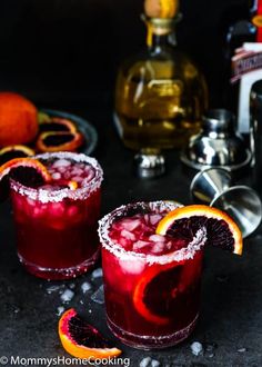 two glasses filled with blood orange margaritas and garnished with sugar on the rim