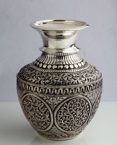 a silver vase sitting on top of a white table