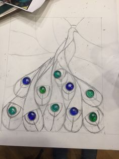 a drawing of a peacock's tail with blue, green and white glass buttons