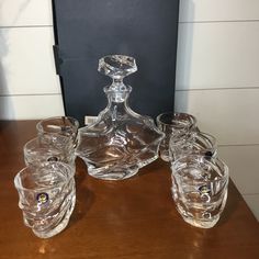 a glass decanter and four glasses on a table