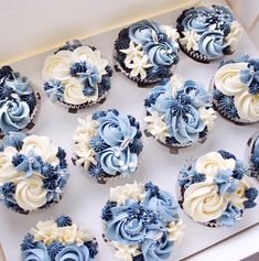 twelve blue and white cupcakes in a box