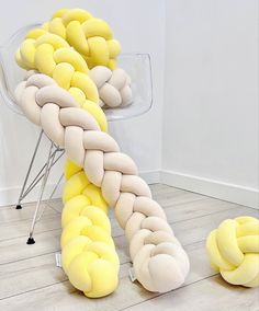 a chair made out of yellow and white pillows sitting on top of a hard wood floor