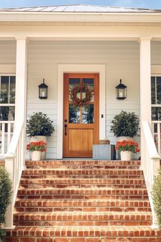 a house with steps leading up to the front door and potted plants on either side