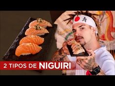 a man is holding sushi in front of him and looking at the camera with his hand