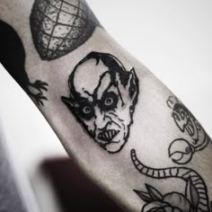 a man's arm with tattoos on it and an image of a demon in the middle