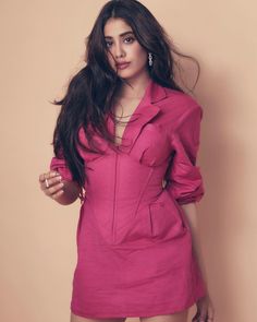 a woman in a pink shirt dress posing for the camera