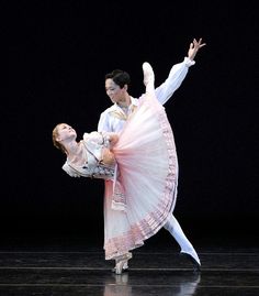 two people in white and pink dance on stage