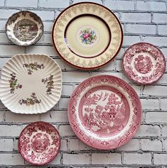 several plates are arranged on a brick wall