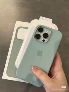 a hand holding an iphone case in front of two boxes with the same product on it