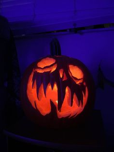 a pumpkin carved to look like a monster's mouth is lit up in the dark