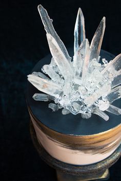 a cluster of ice crystals sitting on top of a black table next to a mirror