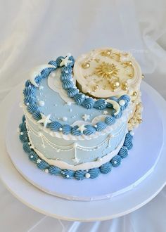 there is a blue and white cake on top of a plate with pearls around the edges