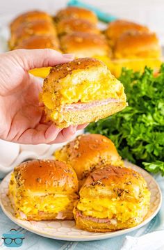 ham and cheese sliders on a plate with parsley sprigs in the background