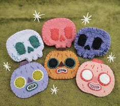 four felt skulls with different colors and sizes