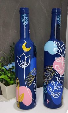 two blue vases sitting on top of a table next to each other with flowers painted on them