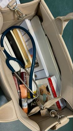 a doctor's stethoscope is in the pocket of a purse filled with medical supplies