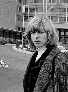 black and white photograph of a person standing in front of a building