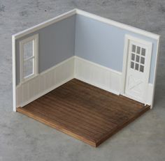 an open dollhouse with a wooden floor and door