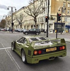 a green sports car is parked on the street