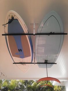 there are two surfboards hanging from the ceiling