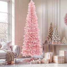 a pink christmas tree in a living room with presents on the floor next to it