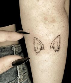 a woman's leg with an angel wing tattoo on the left side of her calf