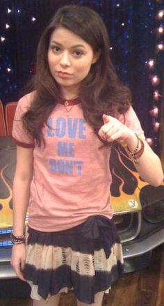 a woman standing in front of a car wearing a t - shirt that says love me don't