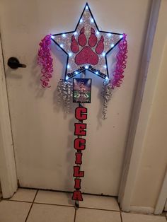 a door with a lighted star on it and pink streamers hanging from the side