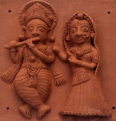 two clay figures are shown on the wall