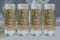 three shot glasses with the names of bride and groom written on them, sitting next to each other