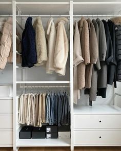 an organized closet with clothes hanging on rails and drawers in front of it, all lined up against the wall