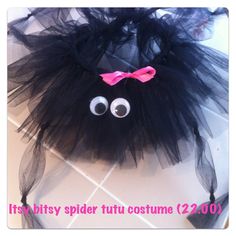 a black spider costume with eyes and a pink bow