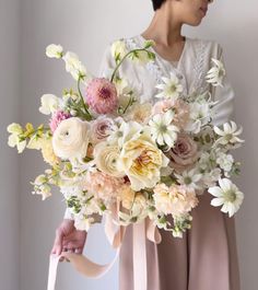 a woman holding a bouquet of flowers in her hands