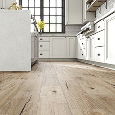 an empty kitchen with white cabinets and wood flooring on the walls is pictured in this image