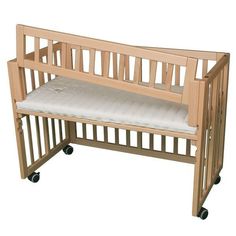 a wooden crib with a cushion on it