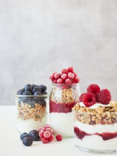 three jars filled with granola, berries and yogurt