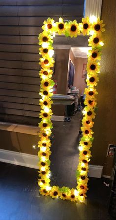 a sunflower decorated mirror in the shape of a letter i is shown with lights