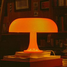 a table lamp sitting on top of a wooden desk next to a bookshelf